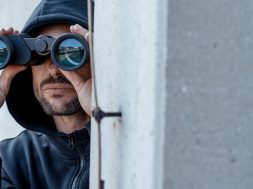 A-man-in-dark-hoodie-with-binoculars.jpg